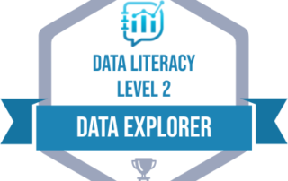 Data Literacy Data Explorer Badge. Badge is a hexagon. Inside at the top is the blue data literacy logo. Below in blue text it reads data literacy level 2. A blue ribbon across the badge reads data explorer in white text. A grey award sits at the bottom of the hexagon.