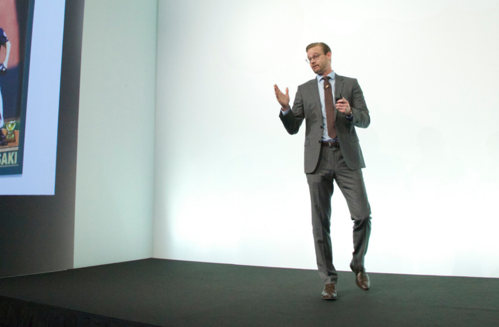 Ben Jones standing on a stage and looking professional in a suit.