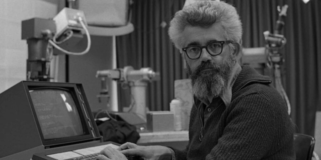 Photo of John McCarthy in his lab at Stanford sitting in front of an old computer